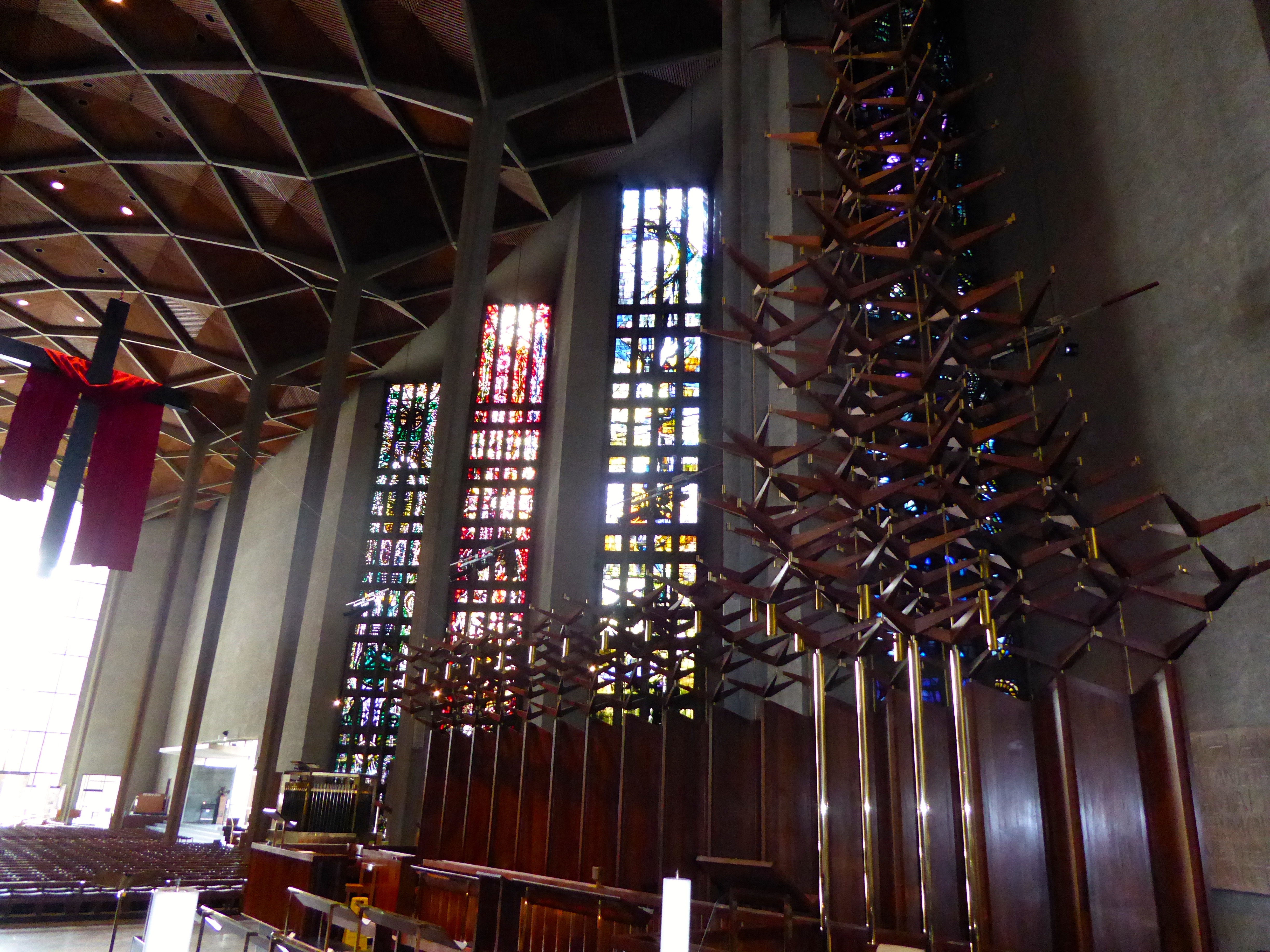 Looking back from the altar where the concrete columns minimise and the stained glass windows appear