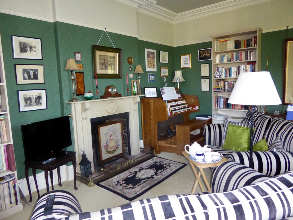 Sitting room with organ in one corner and grand piano in other