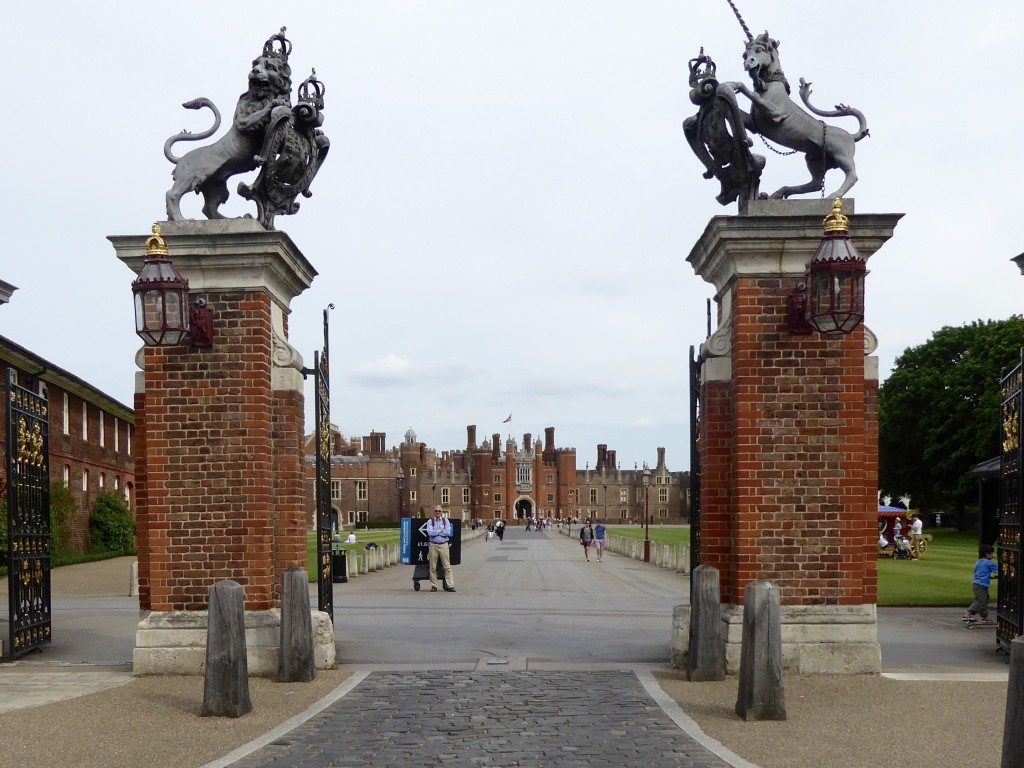 Ed standing in main gates with heraldic statues on the columns